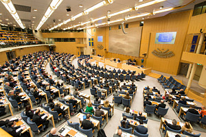 Panoramabild över plenisalen i riksdagen. Ledamöter sitter i sina bänkar.