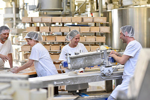 Fyra arbetare i vita kläder i en industrilokal